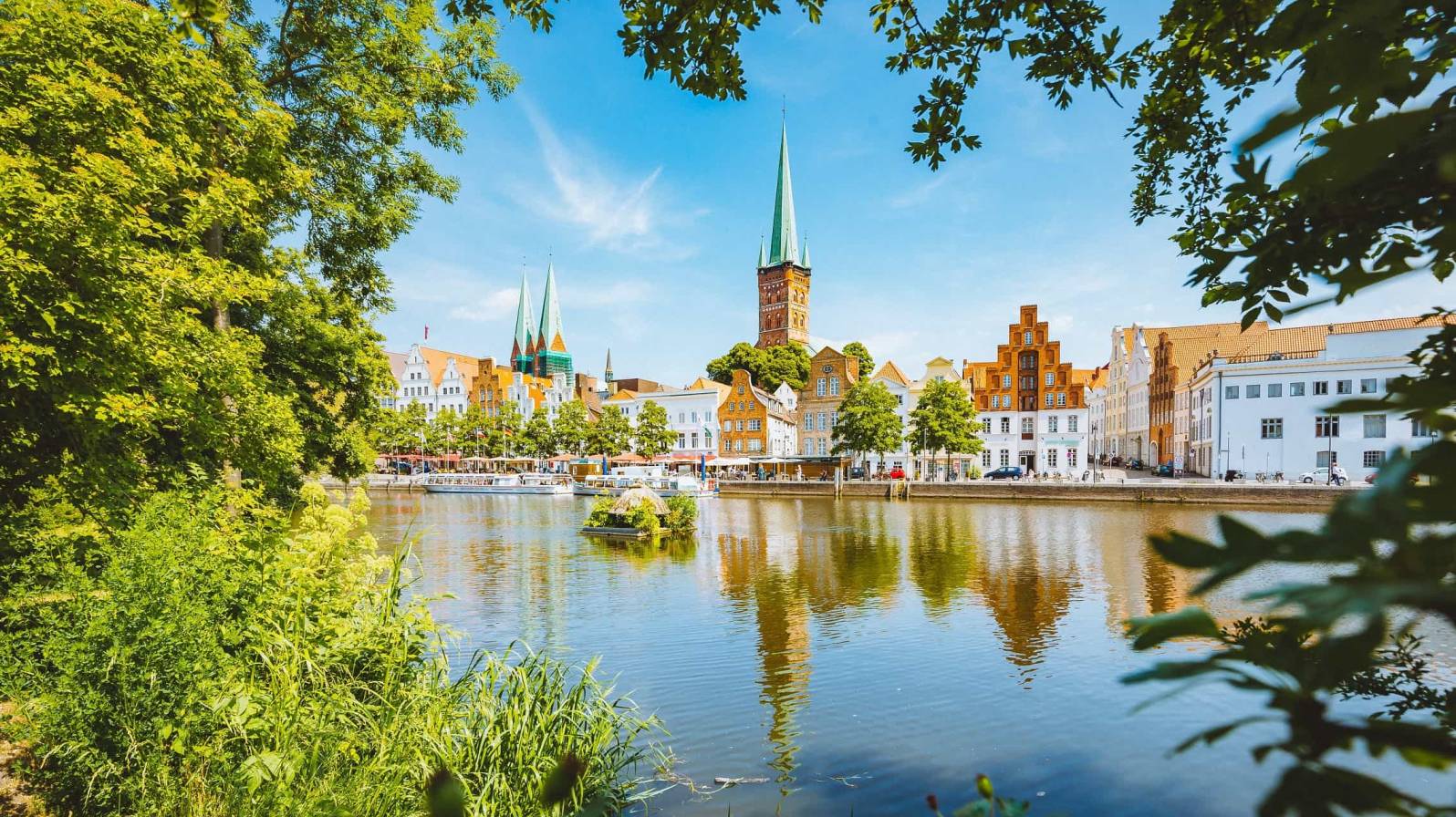 Maata pitkin matkustamalla pääsee Eurooppaan. Kuvassa Lyypekin kaupunki, kuvan edustalla vettä, taustalla historiallinen kaupunki.