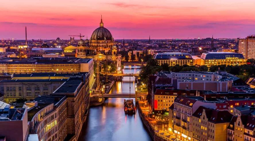 Kuvassa Berliini, yksi parhaista kaupunkilomakohteista Euroopassa, yöaikaan. Kuvassa joki, jonka molemmilla puolilla rakennuksia.