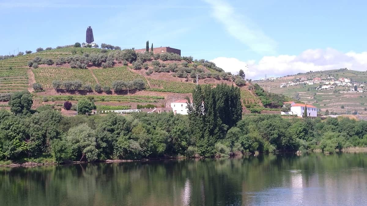 Alt+teksti: Dourojoen laaksossa sijaitseva viinitila. Etualalla Dourojoki ja taustalla kukkuloille kohoavat viiniviljelmät.