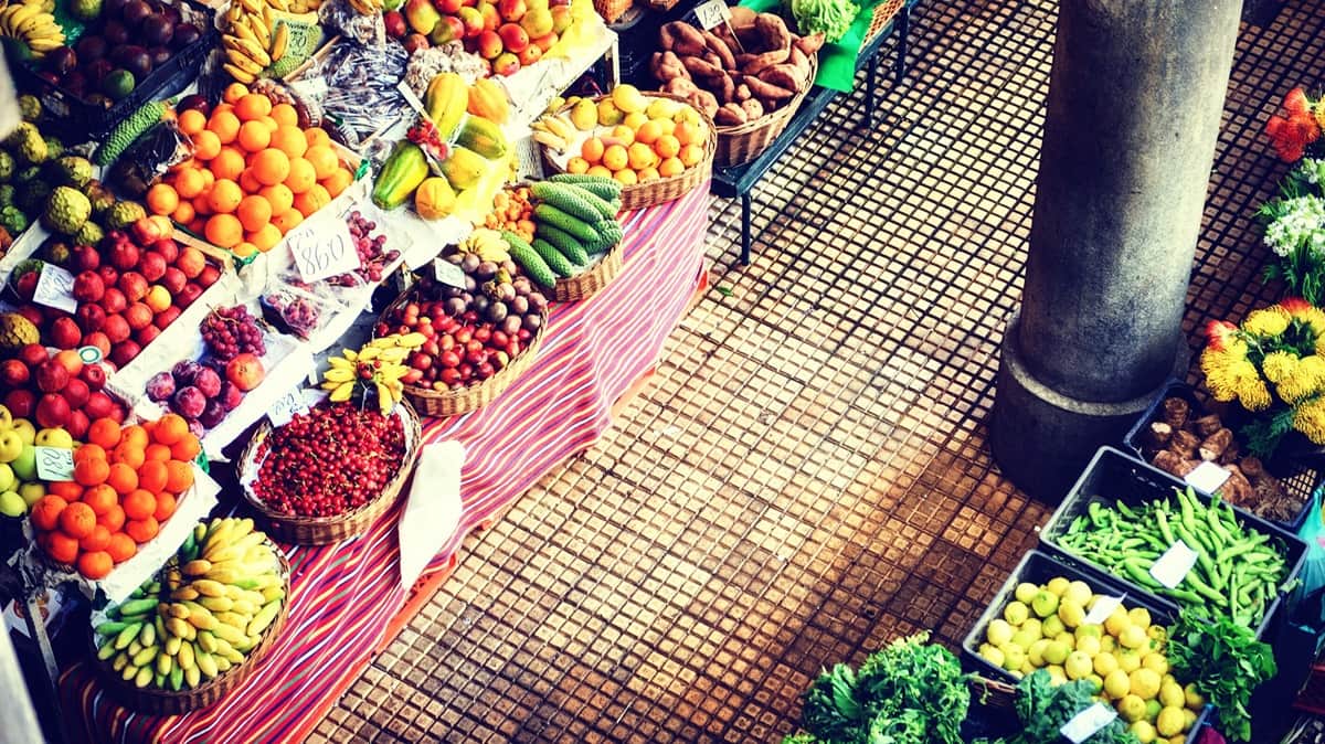 Mercado dos Lavradores kauppahalli Funchal Madeira Funchalin kauppahalli ylhäältä kuvattuna. Maan tasolla useita eri hedelmä- ja vihanneskojuja.