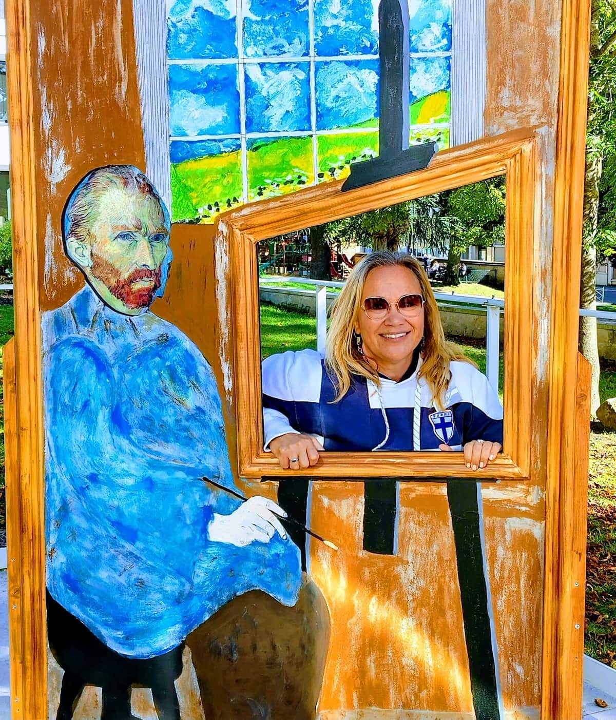 Vincent Van Goghin kuva ja maalaus, jossa on aukko valokuvausta varten. Aukosta kurkistaa ihminen. 