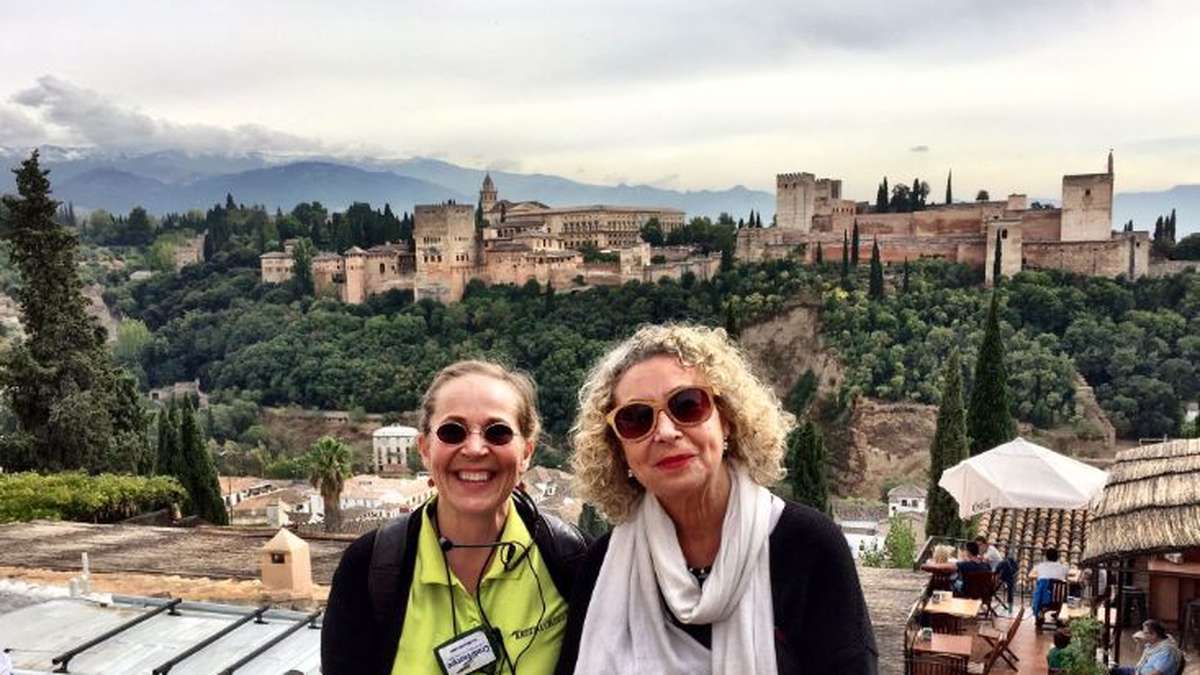 Kristinan matkoilla saa olla yksin tai yhdessä. Kaksi naista ison linnan edustalla. Linnan edustalla vehreää puustoa.