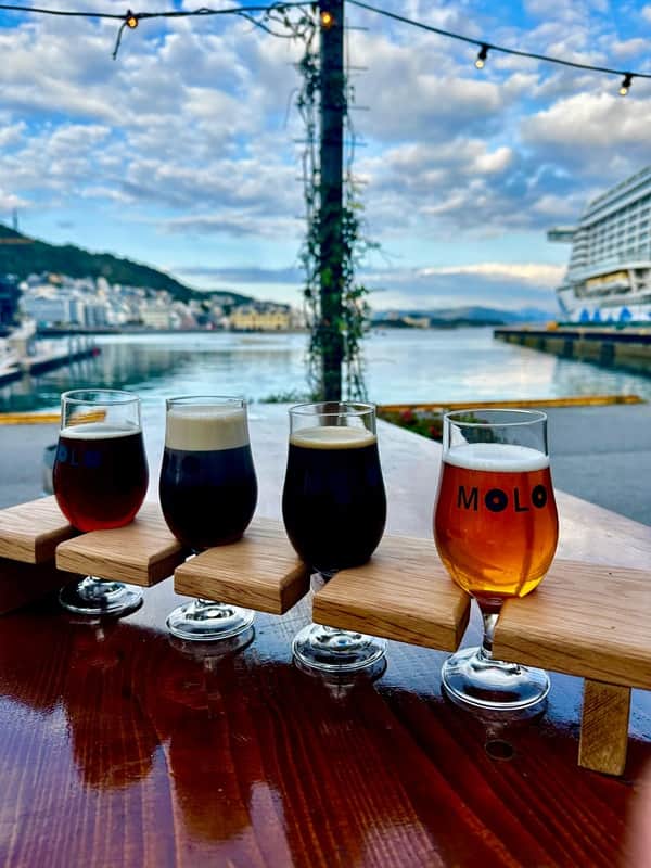 Pienpanimo ruokamatkalla Norjalainen panimo Ålesundissa. Neljä pienpanimo-olutta vierekkäin, taustalla vesistö.