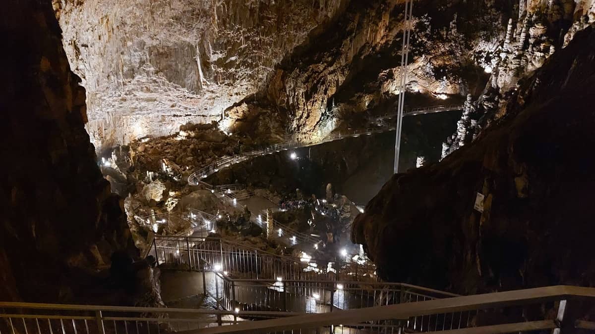 Pimeä maanalainen luola, jossa portaat ja valaistusta.