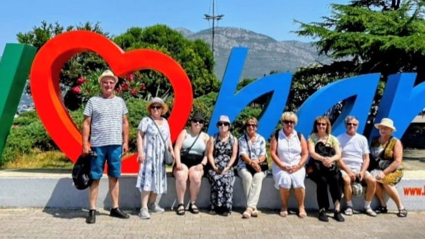 Yhdeksän ihmistä Bar-kyltin edessä.